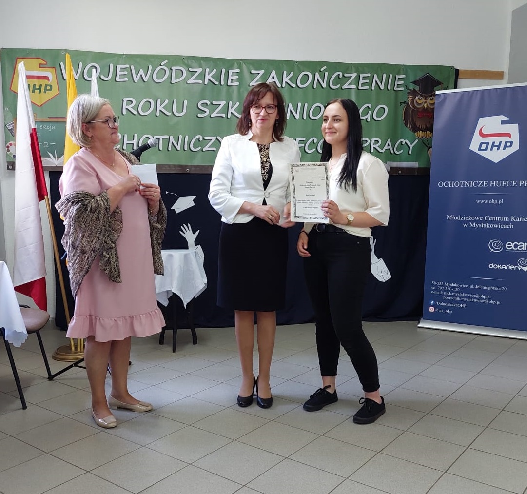 Wojewódzki KOmendant OHP Kierownik Ośrodka OHP w Mysłakowicach wręczają wychowance nagrodę z gratulacjami
